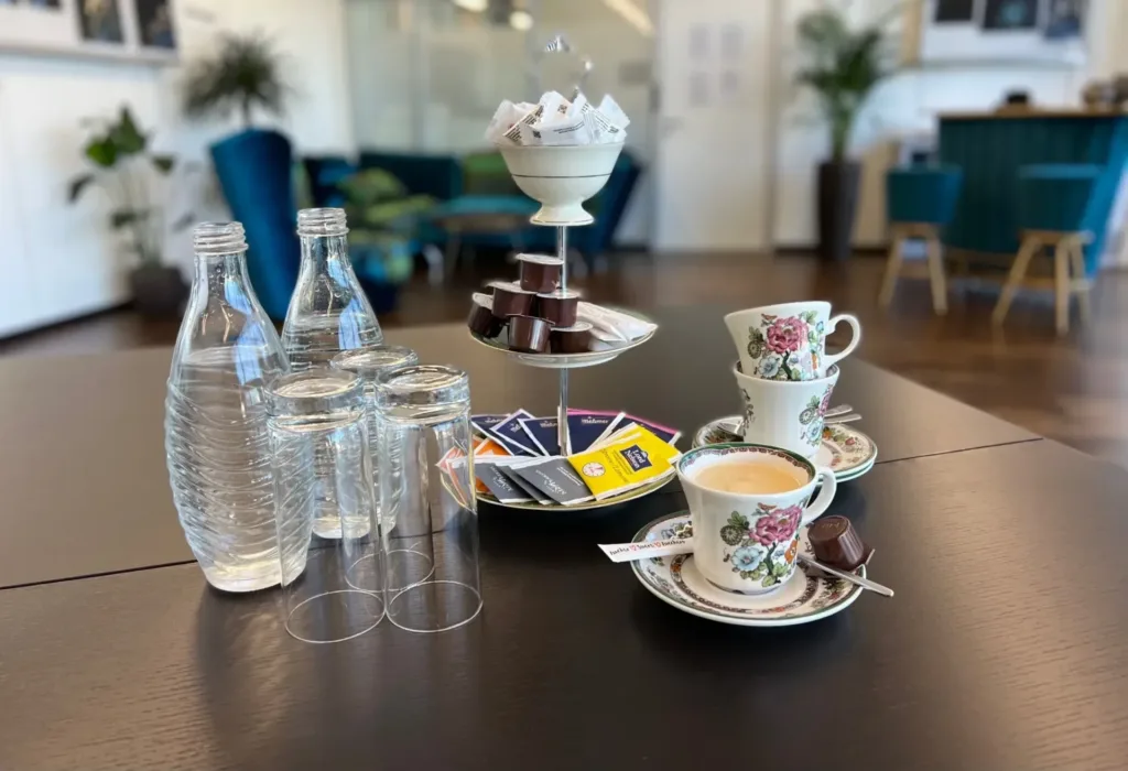 Gedeckter Tisch mit Mineralwasser, Kaffee und Tee