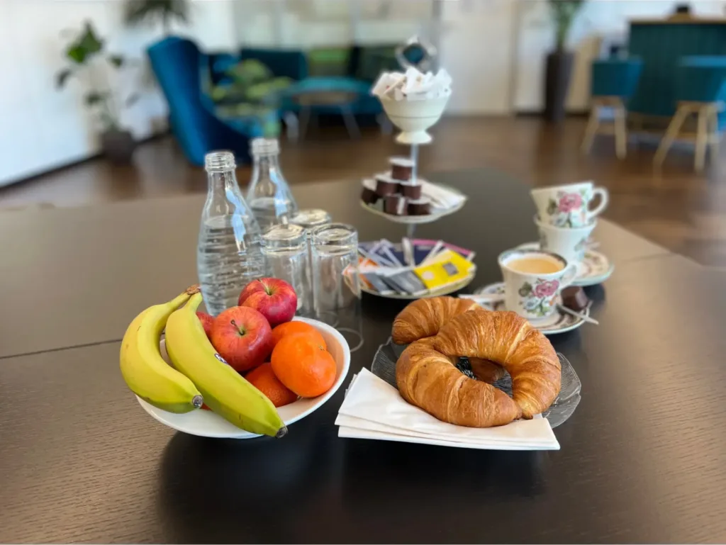 Gedeckter Tisch mit Getr&auml;nken, Gipfeli und Fr&uuml;chten